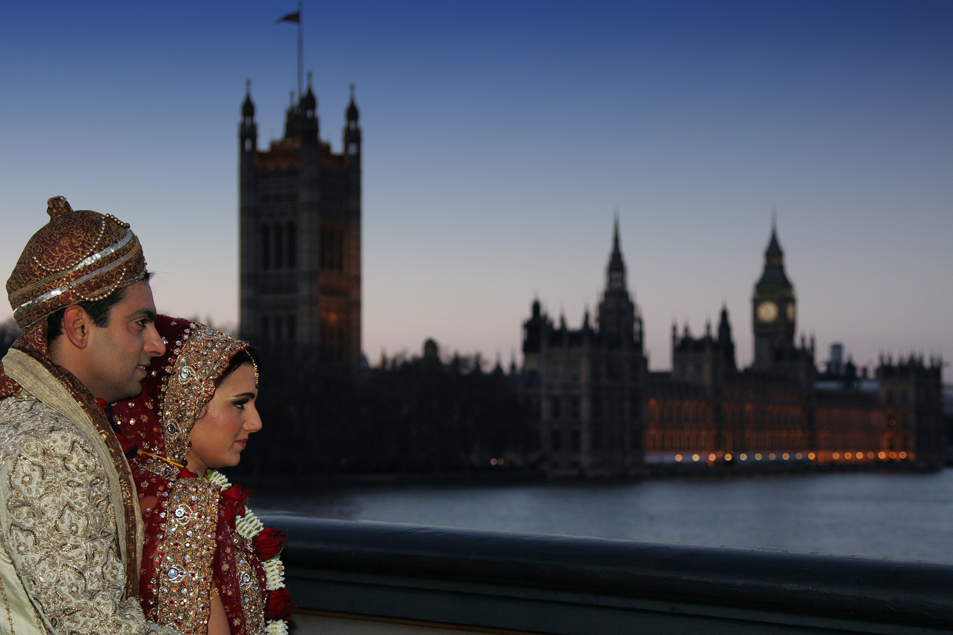 Indian bride and groom night-time portrait by the River Thames with the Houses of Parliament in the background.